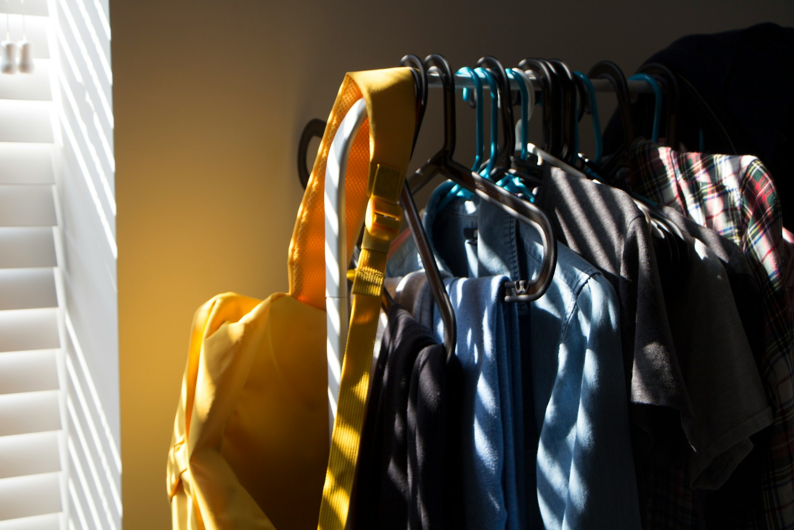 窓辺の自然光に照らされる、整えられた一着一着